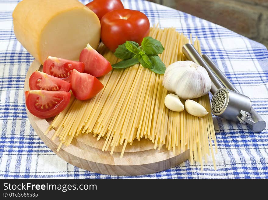 Raw Spaghetti with Red Tomatos and Garlic On Kitchen Table. Raw Spaghetti with Red Tomatos and Garlic On Kitchen Table