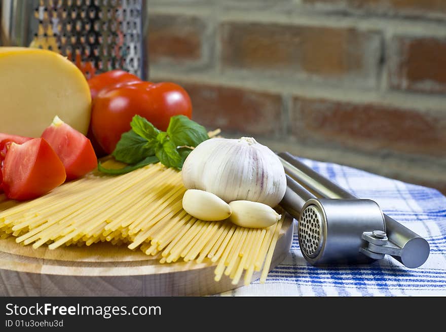 Raw Spaghetti with Red Tomatos and Garlic On Kitchen Table. Raw Spaghetti with Red Tomatos and Garlic On Kitchen Table