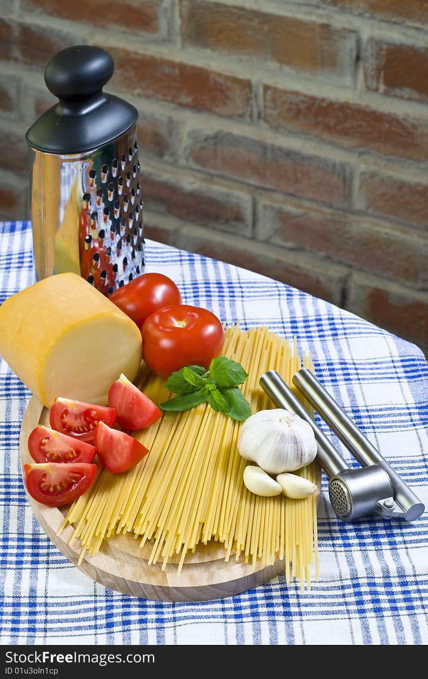 Raw Spaghetti with Red Tomatos and Garlic On Kitchen Table. Raw Spaghetti with Red Tomatos and Garlic On Kitchen Table