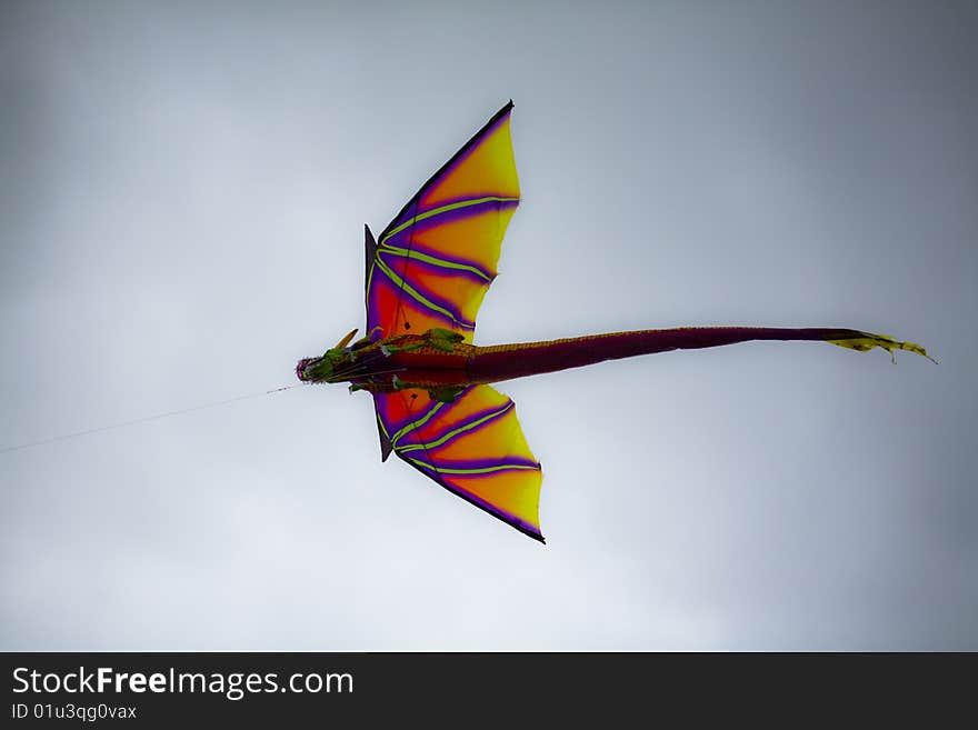 Dragon kite flying in a natural cloudy blue sky background