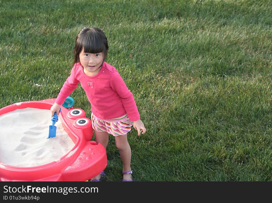 Cute young Asian girl playing with sandbox. Cute young Asian girl playing with sandbox