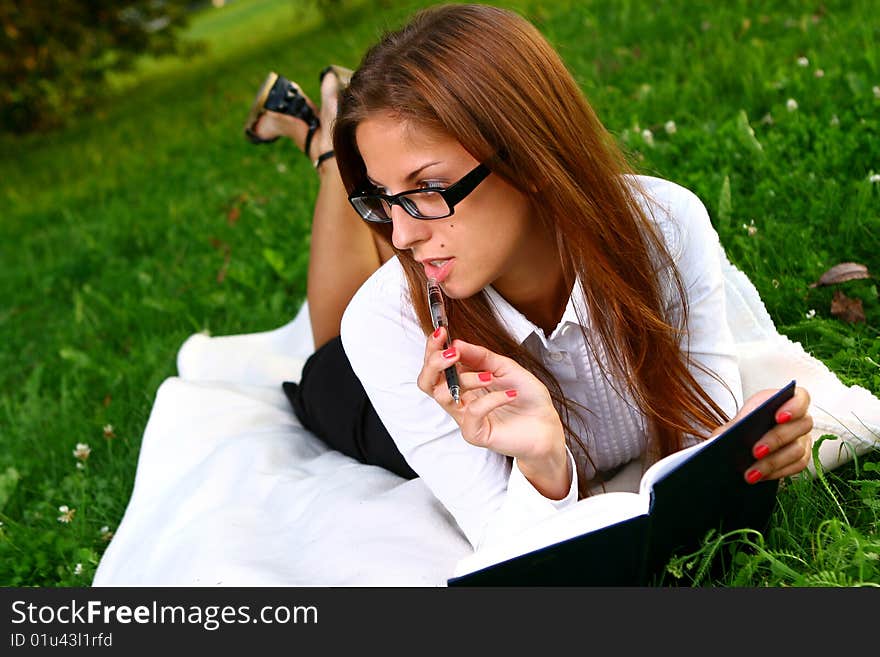 Beautiful young woman studing in park