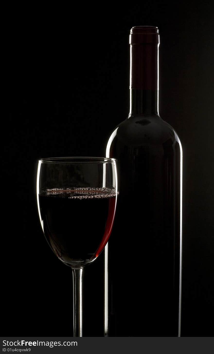 Bottles and glasses of excellent wine on a dark background