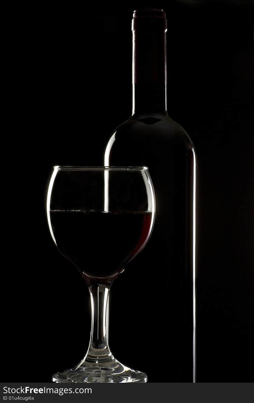 Bottles and glasses of excellent wine on a dark background