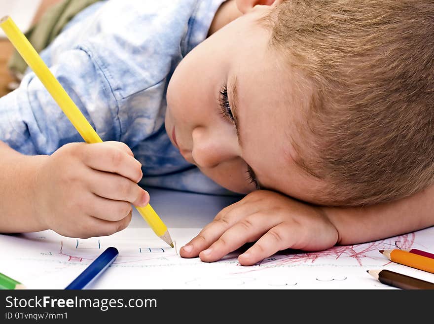 Adorable little boy drawing whit colored pencil