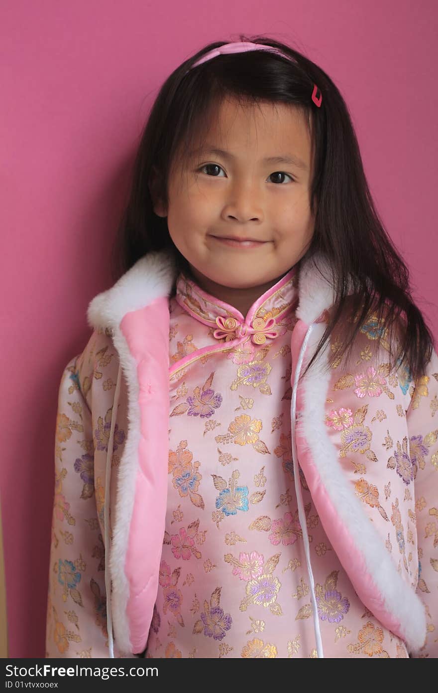 Cute happy little asian chinese girl with pink silk dress on with big smile. Cute happy little asian chinese girl with pink silk dress on with big smile