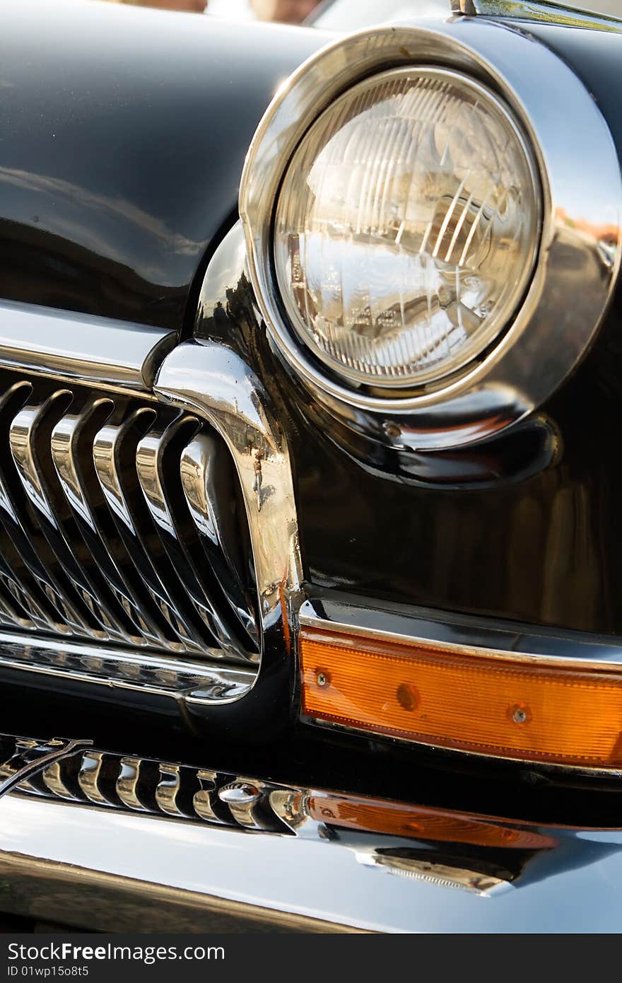 Closeup headlight and grille of an old black classic car. Closeup headlight and grille of an old black classic car