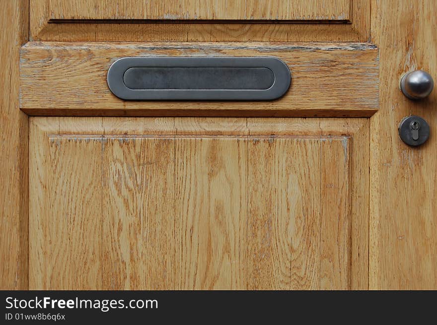 A brown wooden classical door with a mailbox