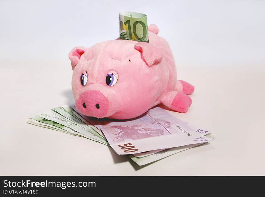 Pink soft piggy bank with 500 and 100 euro banknotes. Saving money. Pink soft piggy bank with 500 and 100 euro banknotes. Saving money