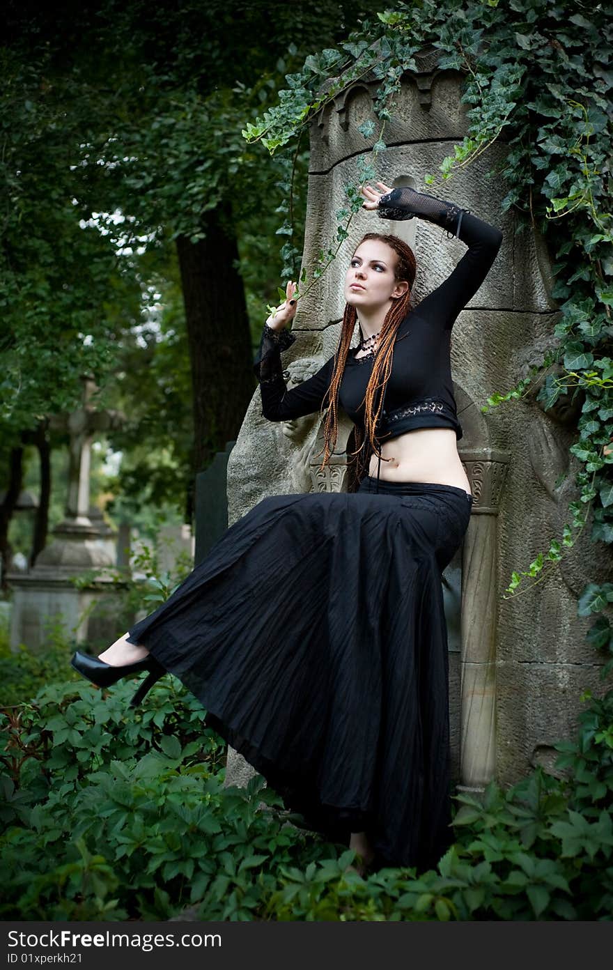 Tender looking gothic girl in black dancing at cemetery