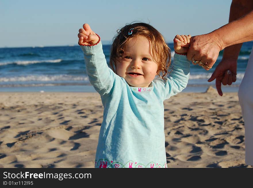 The first steps of a one year old, holding onto her grandmother's hand