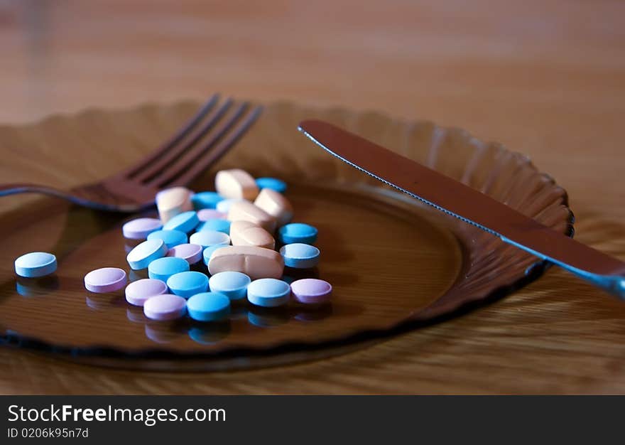 Closeup plate with coloured vitamins, fork and knife. Closeup plate with coloured vitamins, fork and knife