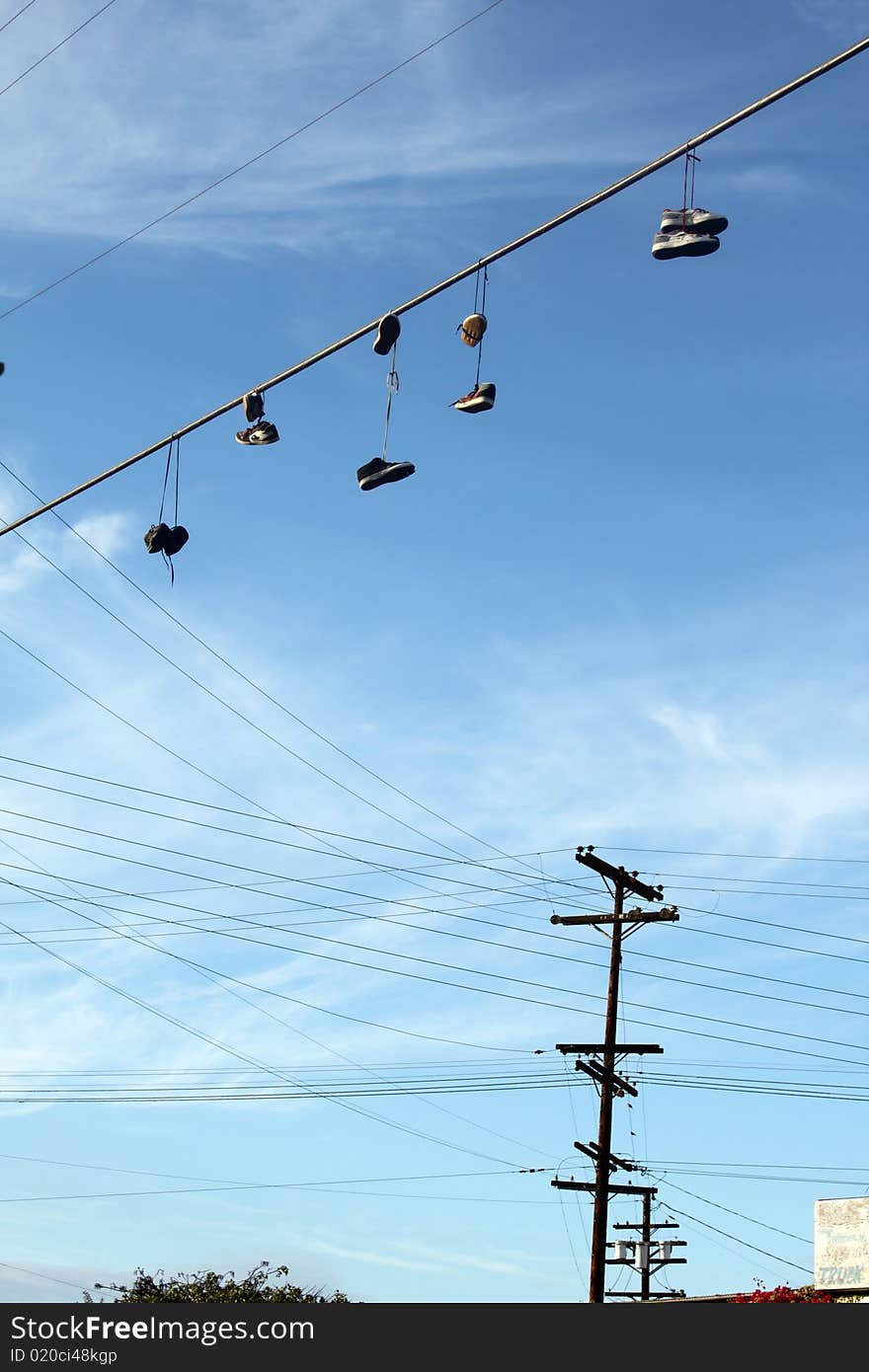 Shoes hanging from shoelaces on power cable. Shoes hanging from shoelaces on power cable