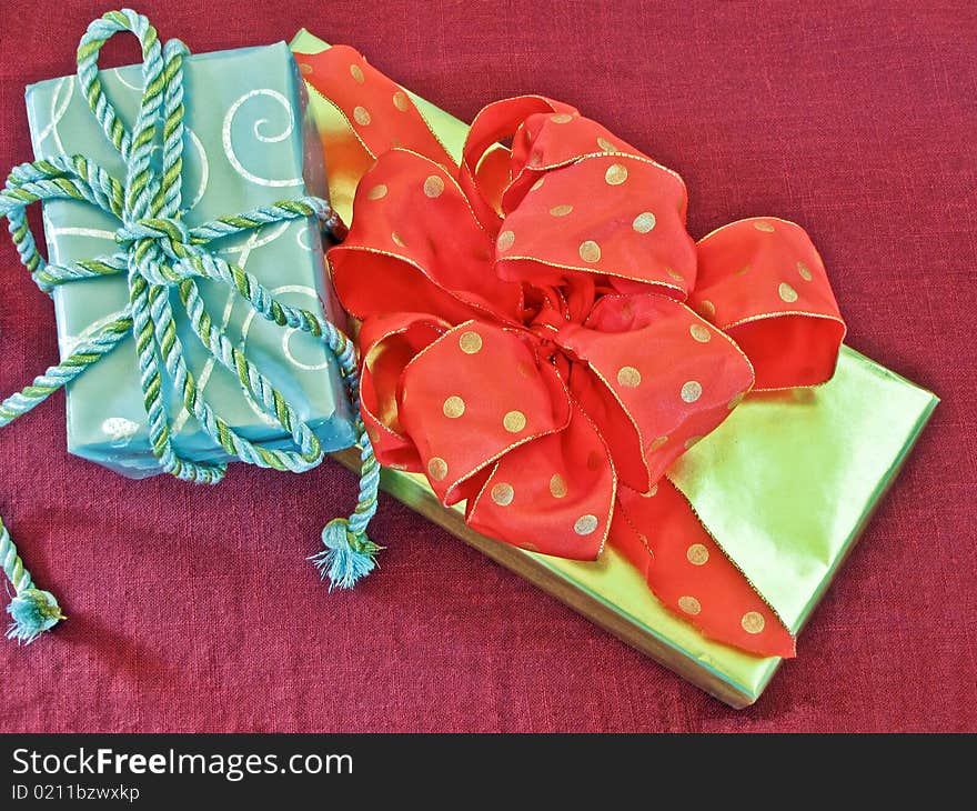 Silver and gold gifts on a red background with ribbons and bows. Silver and gold gifts on a red background with ribbons and bows