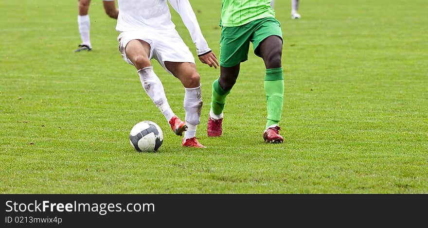 Soccer players running after the ball