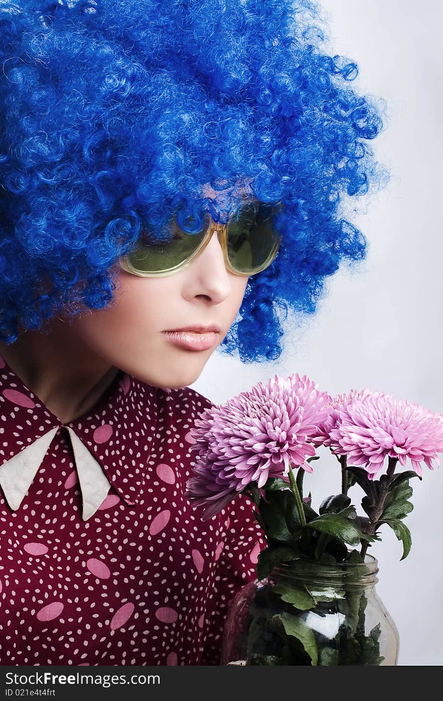 Young beauty clown in dark blue wig with flowers. Young beauty clown in dark blue wig with flowers