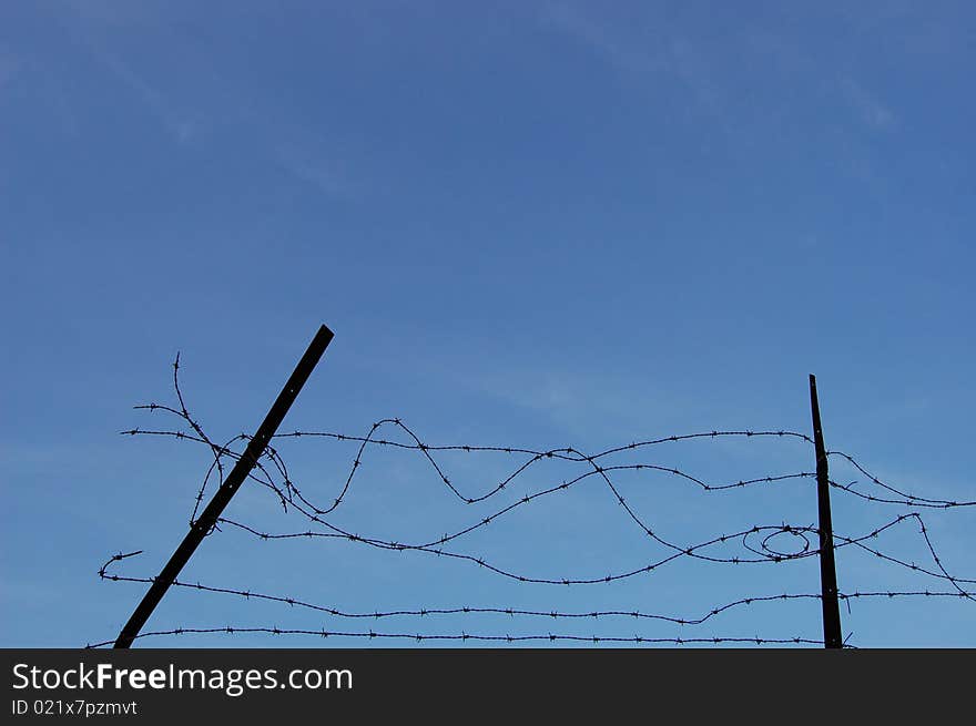 Barbed wire with a blue sky background. Barbed wire with a blue sky background