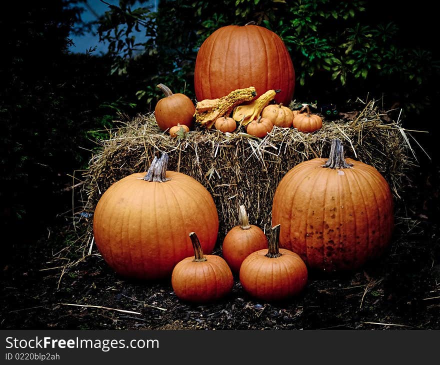 Halloween Pumpkins On A Hay Bale At Dusk