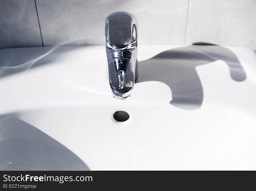 Ceramic white washing sink with a modern faucet