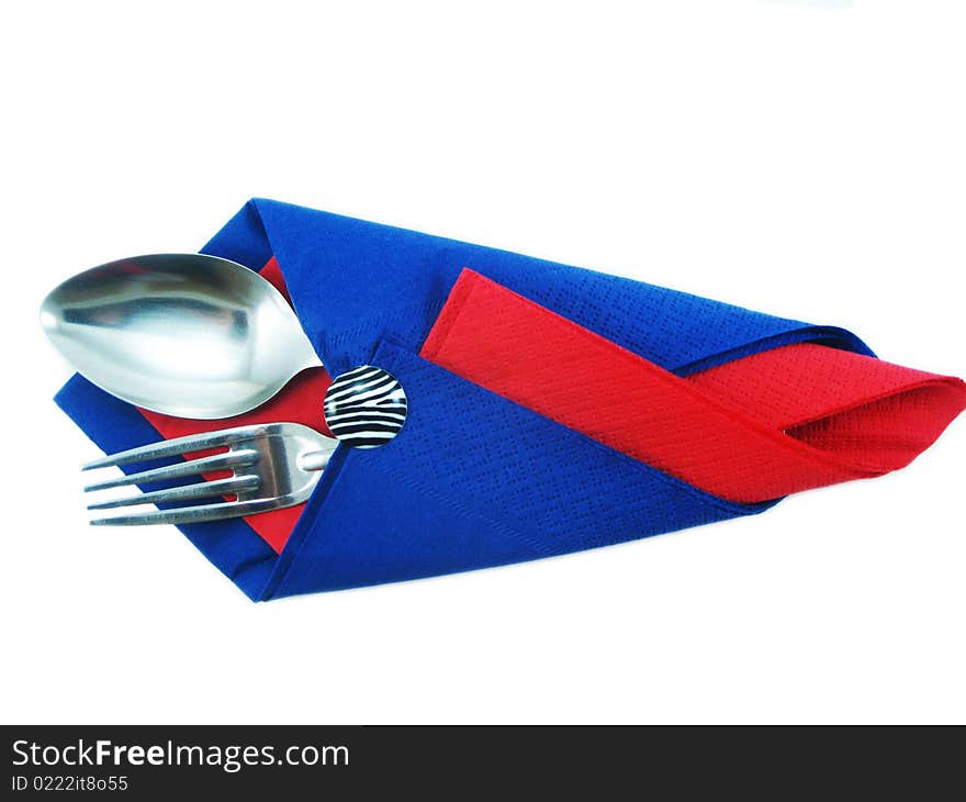 Dining facilities, plug and spoon in a red and dark blue napkin