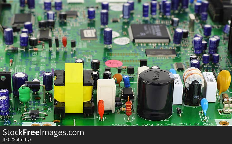 The modern printed-circuit board with various electronic components. In the foreground power supply components. Selective focus. The modern printed-circuit board with various electronic components. In the foreground power supply components. Selective focus.