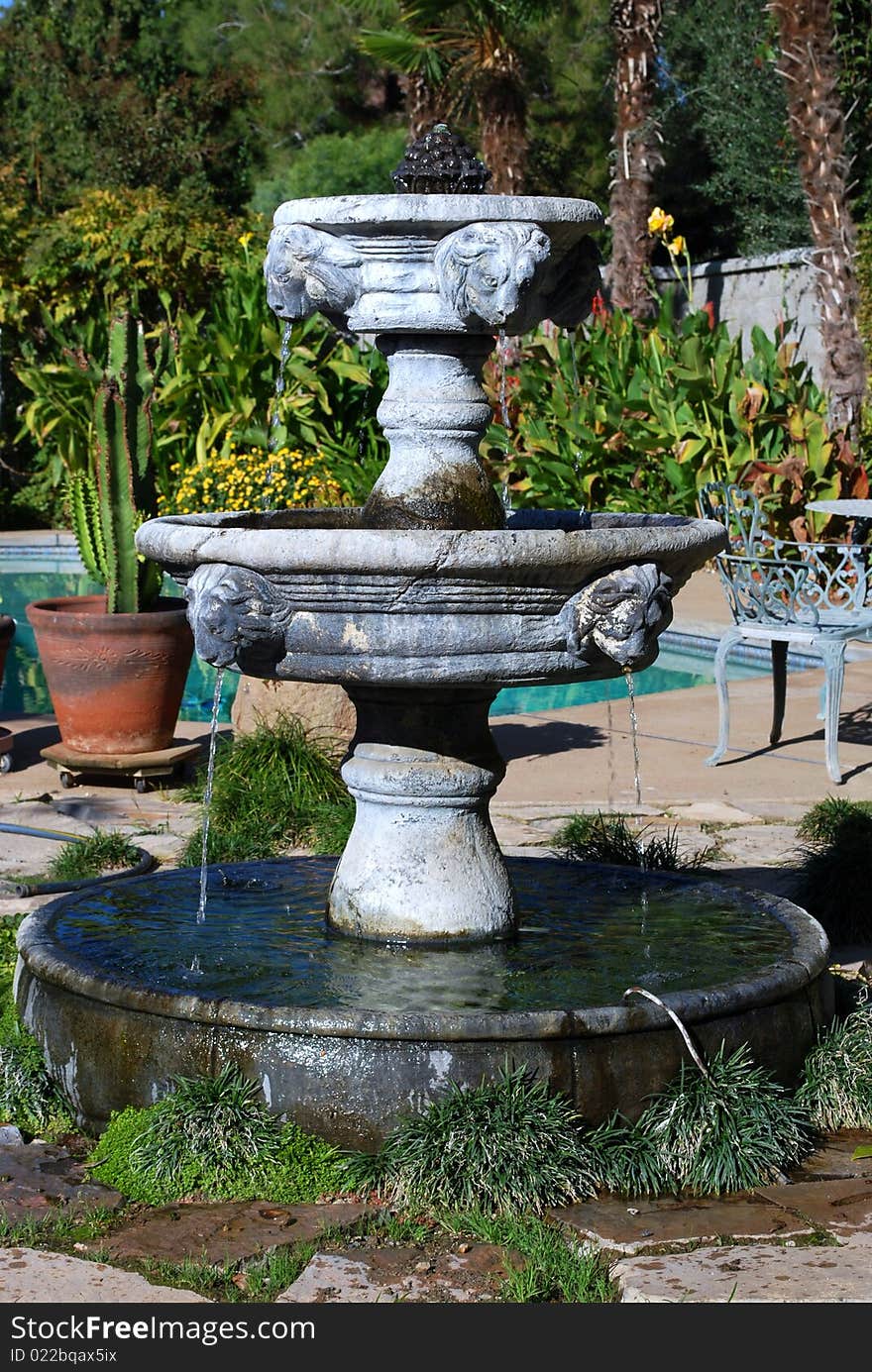A water fountain waits to entertain guests on a sunny patio.