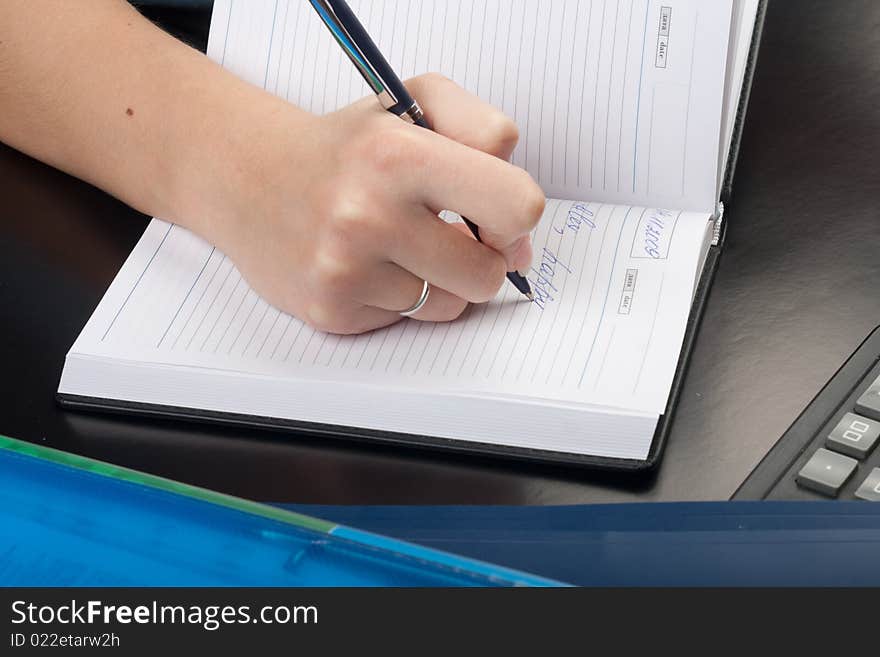 Young woman writing with pen on paper