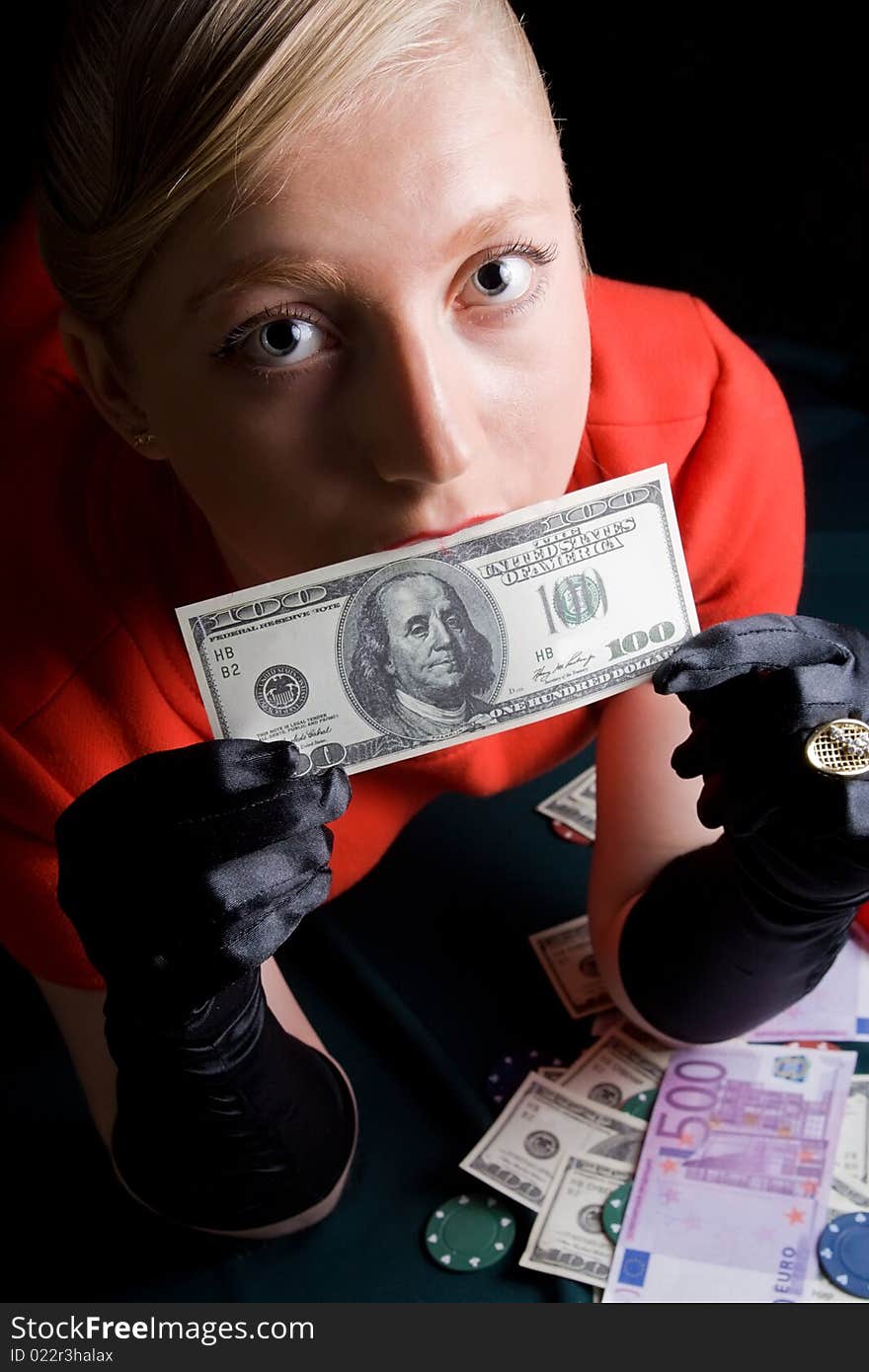 Blond gambler kissing a dollar note. Blond gambler kissing a dollar note