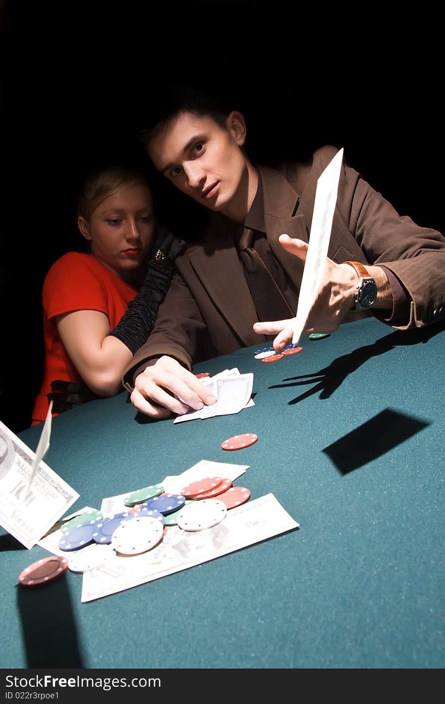 Young man throwing money on the table while playing cards. Young man throwing money on the table while playing cards