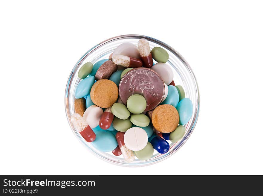 Fifty cents in glass saucer full of different pills on white background. Fifty cents in glass saucer full of different pills on white background