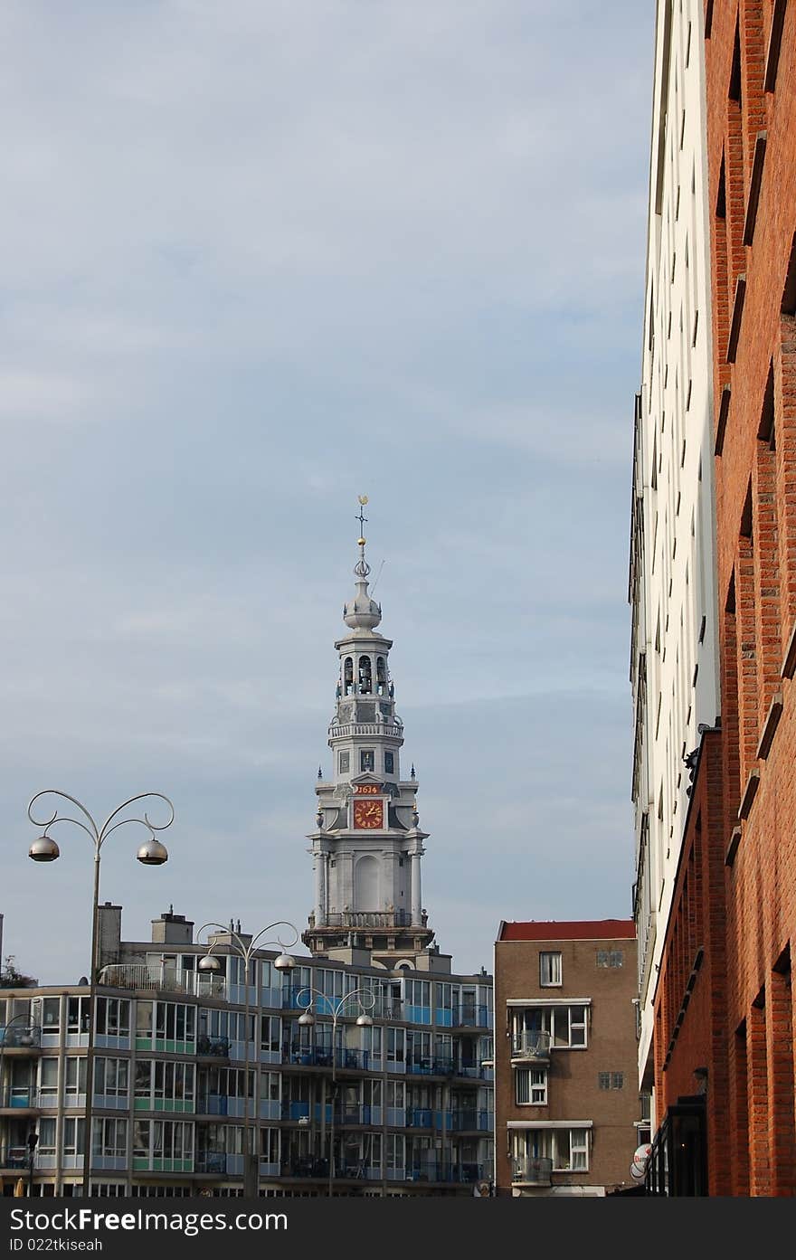 An old Amsterdam tower with a modern building on the right side. An old Amsterdam tower with a modern building on the right side