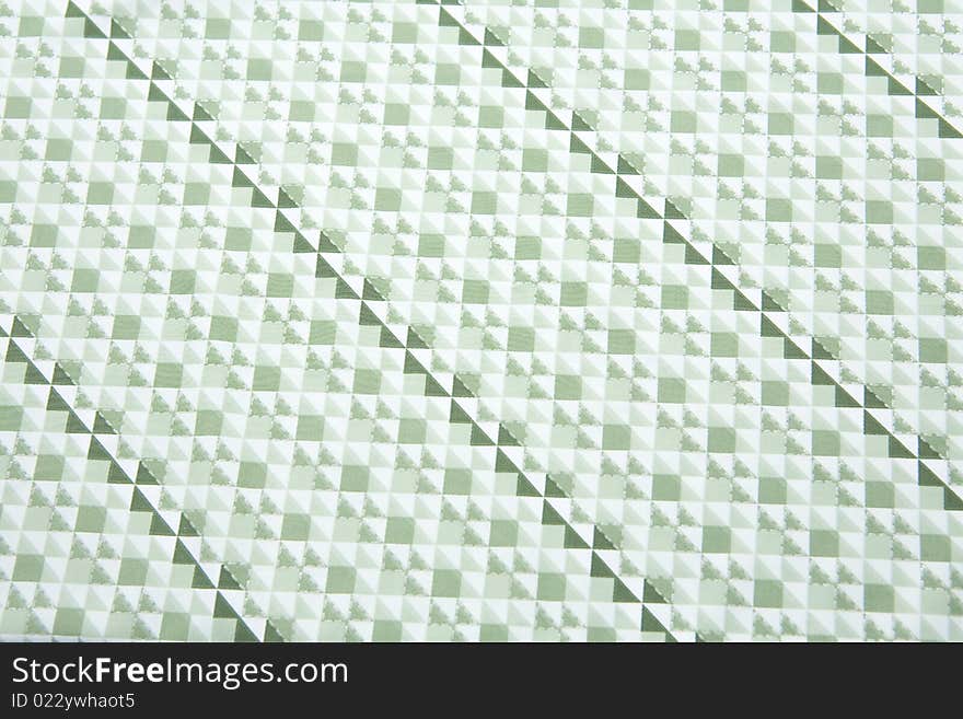 A close up of fabric with patern of greenish triangles