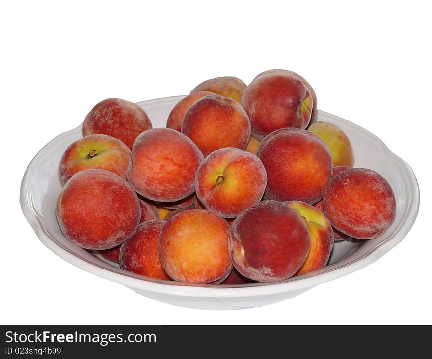 Ripe peaches in plate. Isolated on white