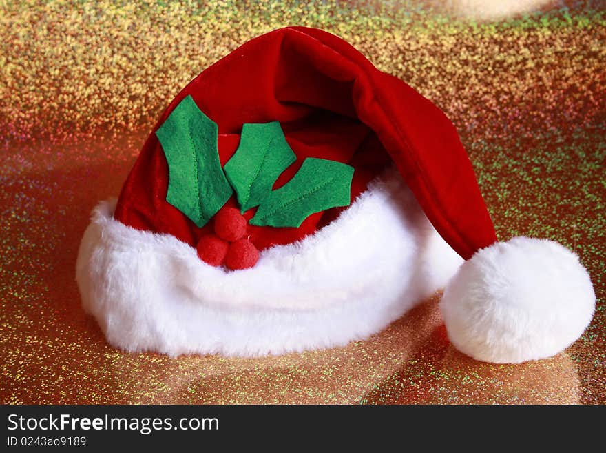 Santa Claus Hat with holly leaves gold back round. Santa Claus Hat with holly leaves gold back round