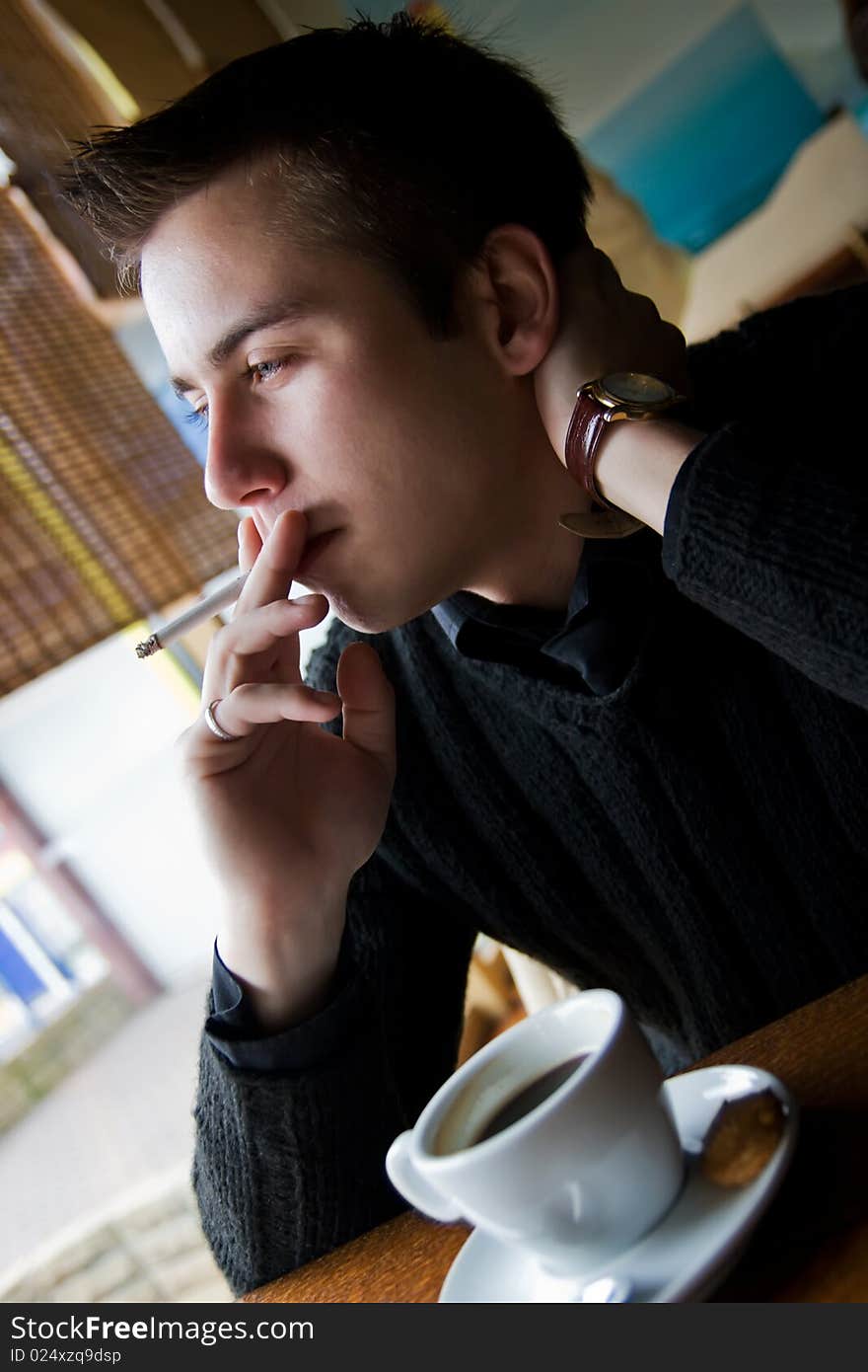 Young Man Smoking In A Restaurant