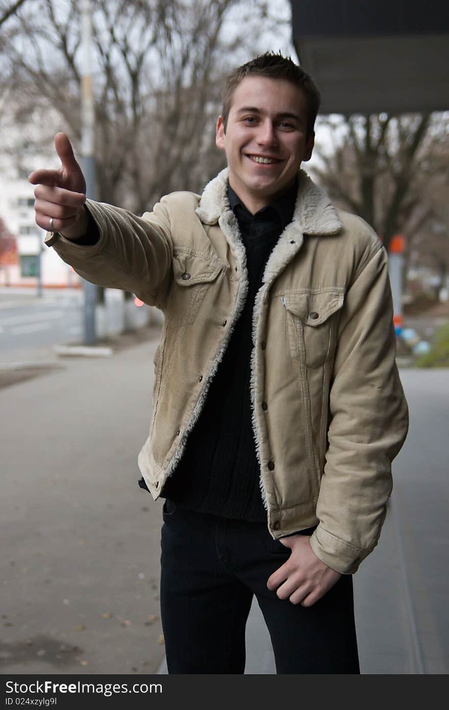 Young man pointing in positive mood pointing with his finger. Young man pointing in positive mood pointing with his finger