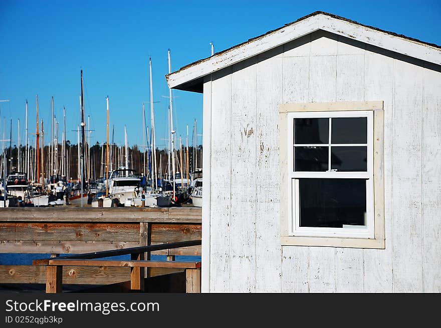 Old boat house on marina with boats in the background