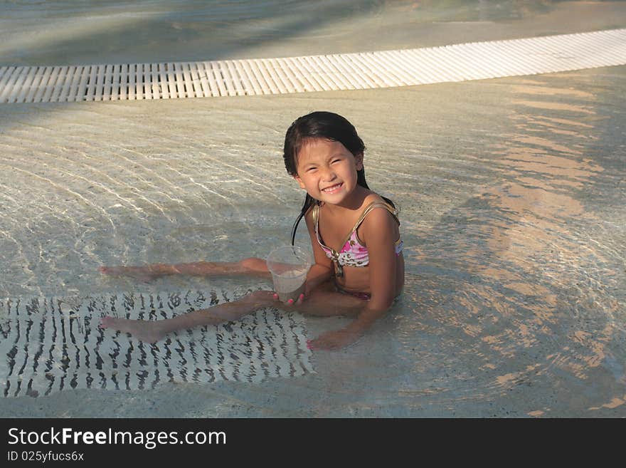 Little asian chinese girl sitting in a pool. Little asian chinese girl sitting in a pool