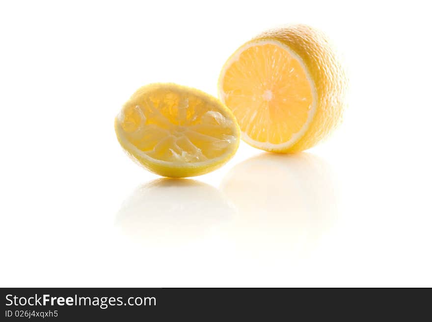 Squeezed lemon lie on the white reflecting white surface