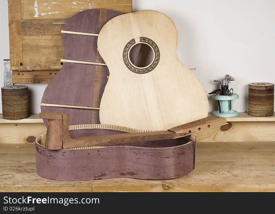 Details of the classical guitar on a table in the wizard, precious woods used in this work, the master was prepared to collect his best musical instrument, the upper deck from the choicest of the Siberian cedar, shell bottom deck and the neck of the best varieties of the African tree