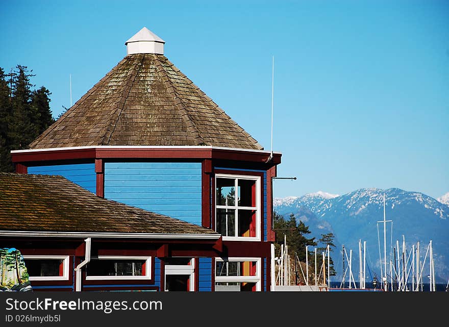 Harbor boathouse against blue sky and mountains