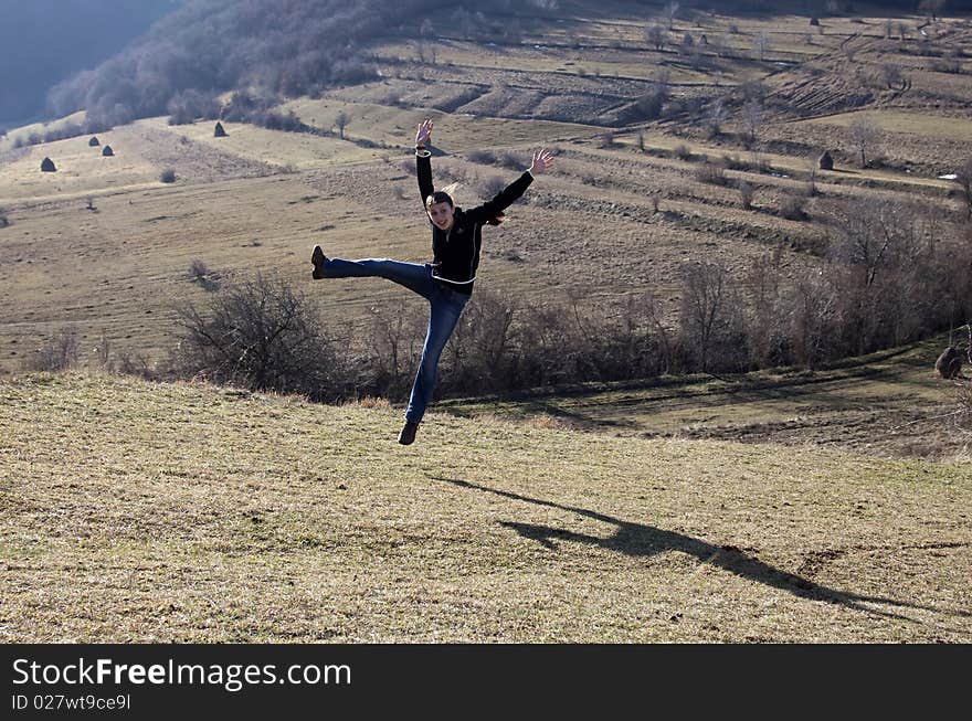 Happy young woman jumping in field