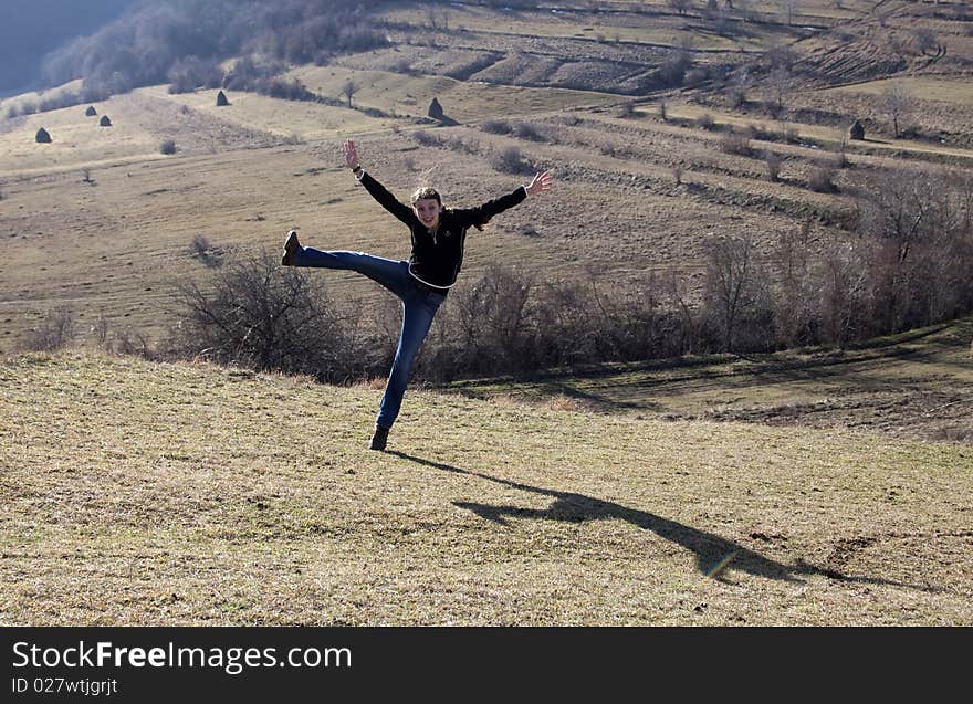 Happy young woman jumping in field