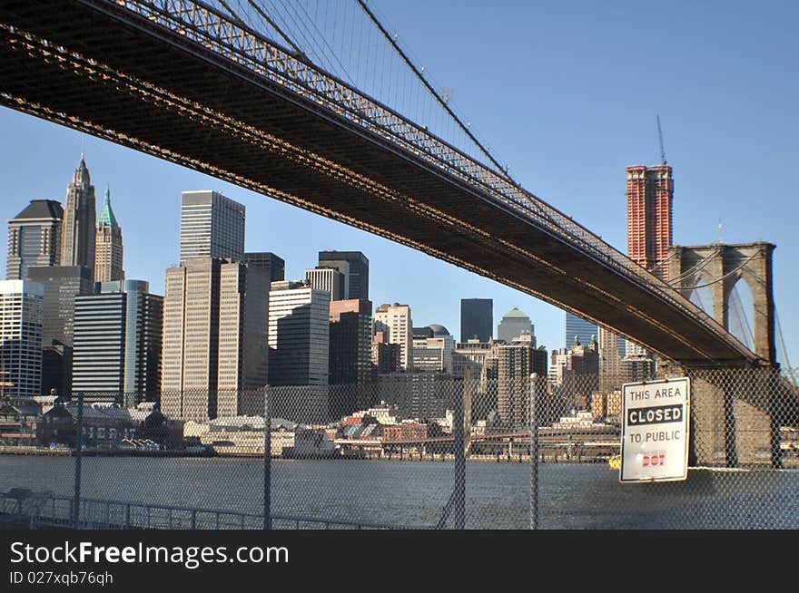 Lower angle view of Brooklyn bridge over East river with Manhattan skyline in background, New York city, U.S.A.