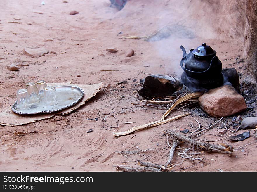 Petra, the fabled rose red city, half as old as time, is a well known ancient Nabataean city in the south of Jordan. Due to its breathtaking grandeur and fabulous ruins, Petra was recognized as a World Heritage Site by UNESCO in 1985. In this picture a kattle of jordan bedouin tea boiling on a camp fire of juniper wood. Teas are often offered to tourists that stop at the many stall to buy goods and souvenires. Petra, the fabled rose red city, half as old as time, is a well known ancient Nabataean city in the south of Jordan. Due to its breathtaking grandeur and fabulous ruins, Petra was recognized as a World Heritage Site by UNESCO in 1985. In this picture a kattle of jordan bedouin tea boiling on a camp fire of juniper wood. Teas are often offered to tourists that stop at the many stall to buy goods and souvenires.