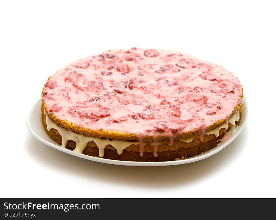 Homemade strawberry cake on a platter, isolated on white background