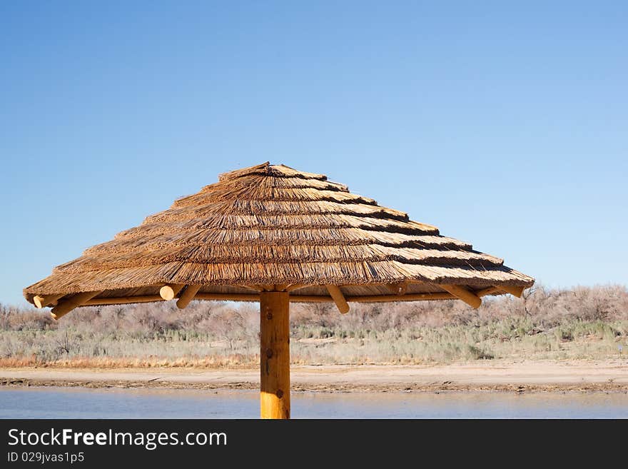 A thatched roof palapa hut invites vacationers to lounge in the shade