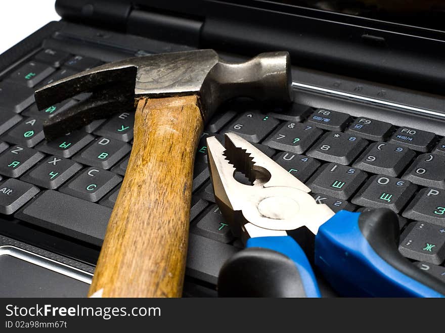 Hammer and pliers on a laptop