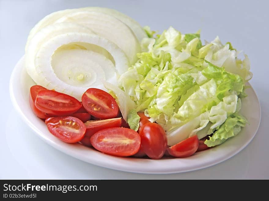 Fresh cut vegetables on a plate in a studio environment