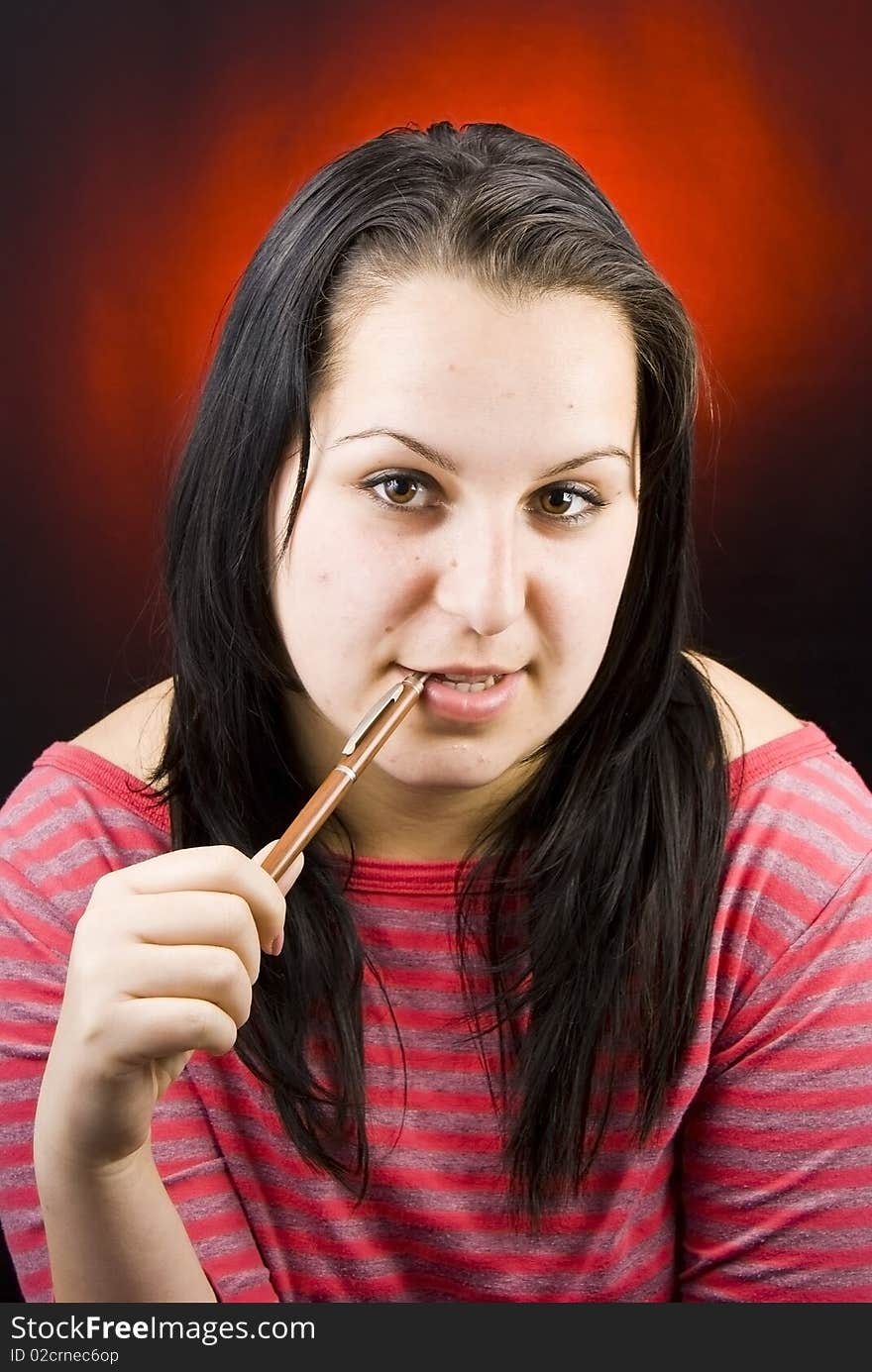 Portrait of natural young girl when taking a break while learning studying with pencil in mouth